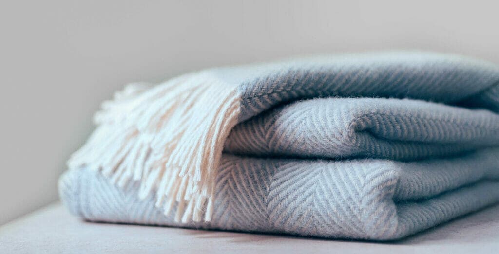 Insulate a dog crate with quilts or blankets