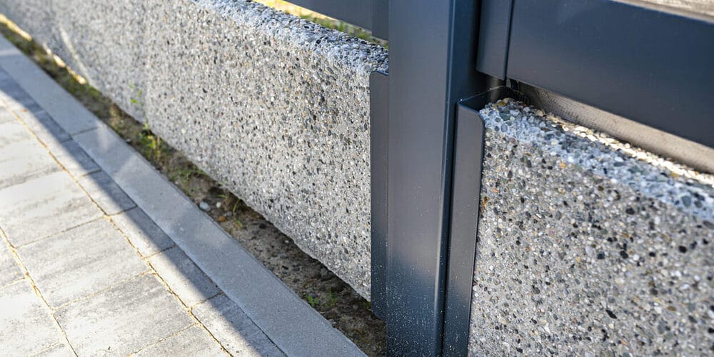 Pour concrete along the base of the fence Pour concrete along the base of the fence